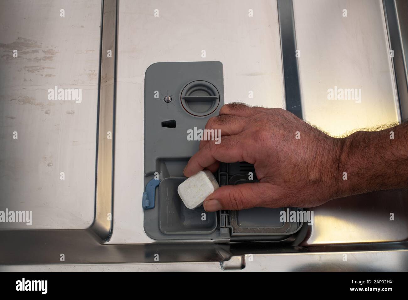 hand putting dishwashing tablet in machine.daily chores ,house work