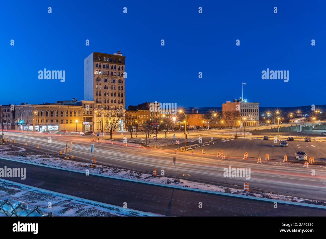 UTICA, NY - JAN 17, 2020: Wide Aerial Night View of Downtown Utica Streets and Cars Trail Lights with the Genesee Tower in the Background. Stock Photo