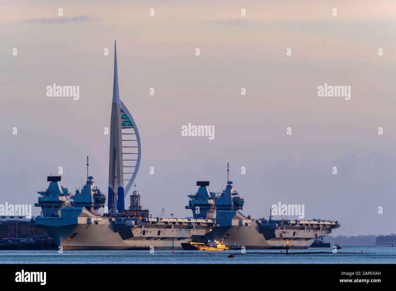 HMS Prince of Wales & HMS Queen Elizabeth docked in Portsmouth dockyard with the spinnaker tower in view. Stock Photo