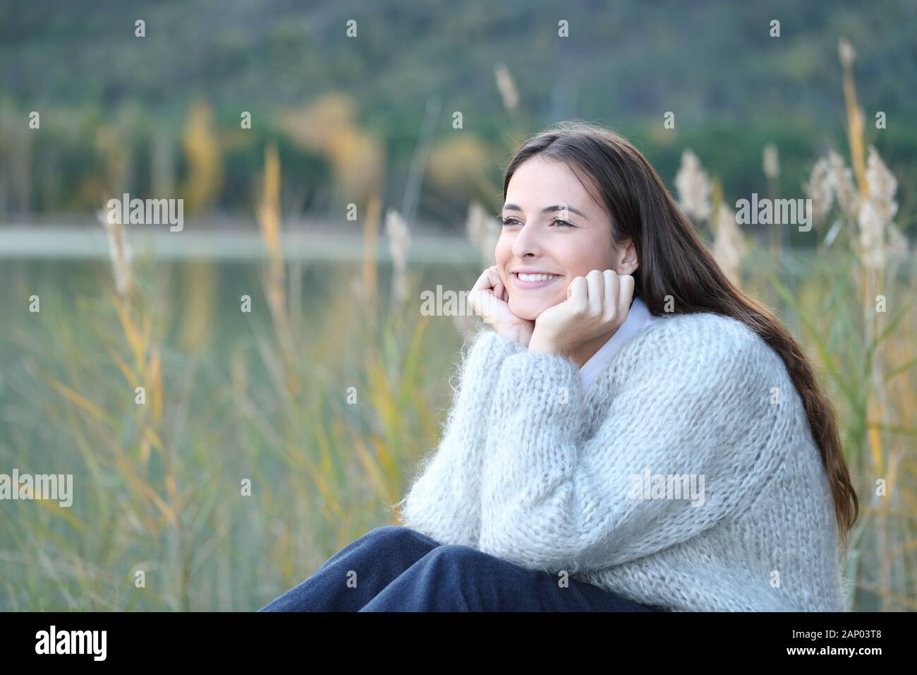 Candid girl relaxing contemplating views sitting in a lake enjoying nature in winter Stock Photo