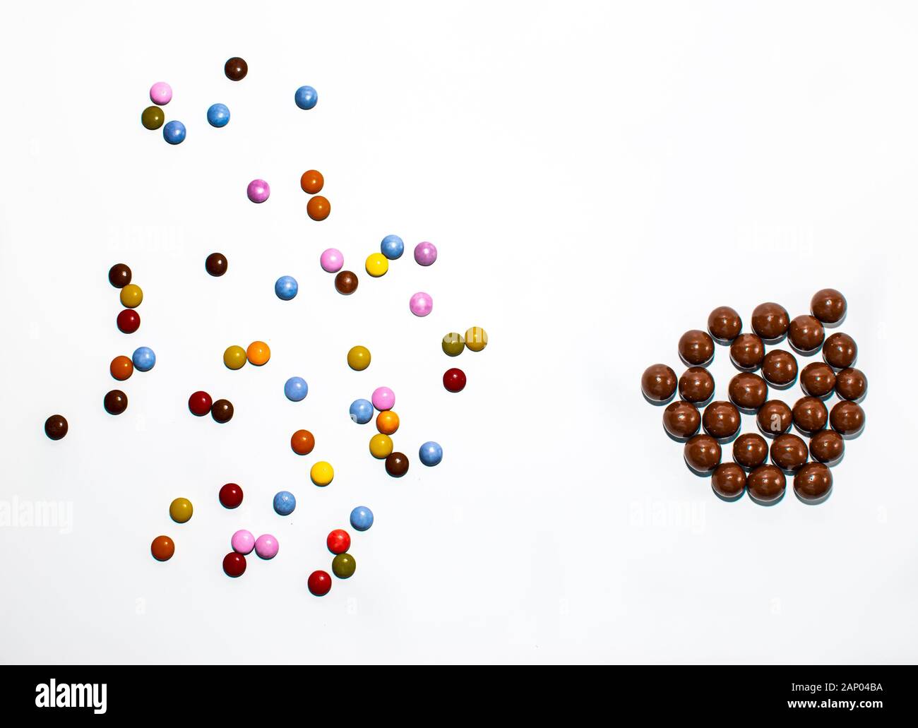 Colored balls standing divided, while brown balls are standing together. The same type stay together, the different stay alone Stock Photo