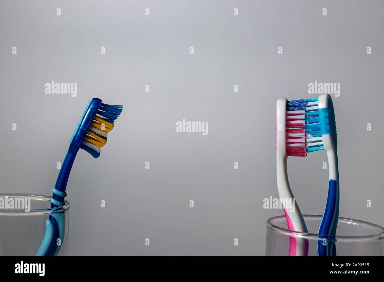 A jealous toothbrush watching at other two toothbrushes as they are kissing Stock Photo