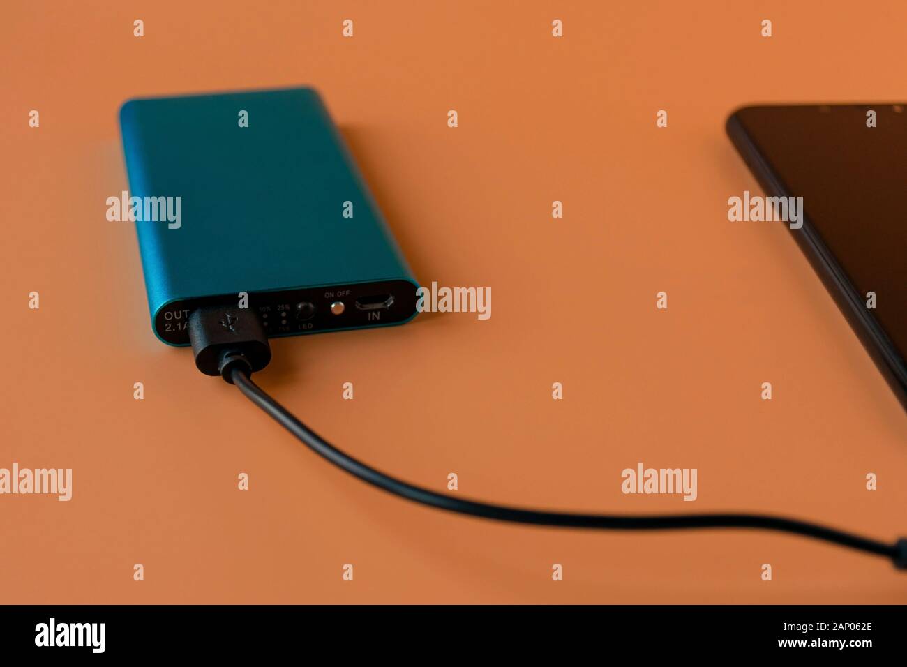 Power bank for charging mobile devices and devices. Blue smartphone ...