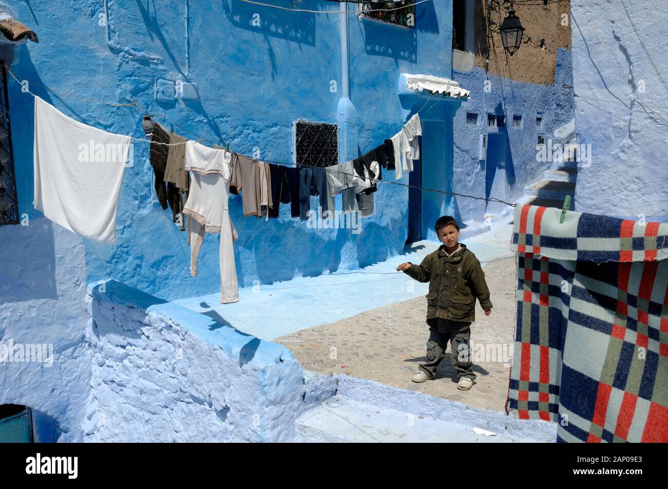 Moroocan Boy & Laundry or Washing Hanging on Washing Line in Streets of the Old Town or Medina Chefchaouen Morocco Stock Photo