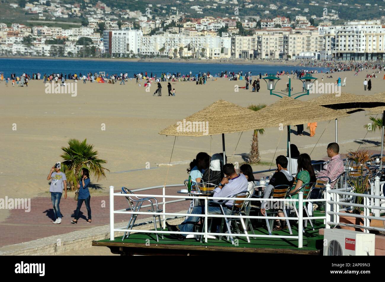 Middle-Class Moroccans in Bar Cafe overlooking the Town Beach & Seafront Lined with Bars & Restaurants Tangier or Tangiers Morocco Stock Photo