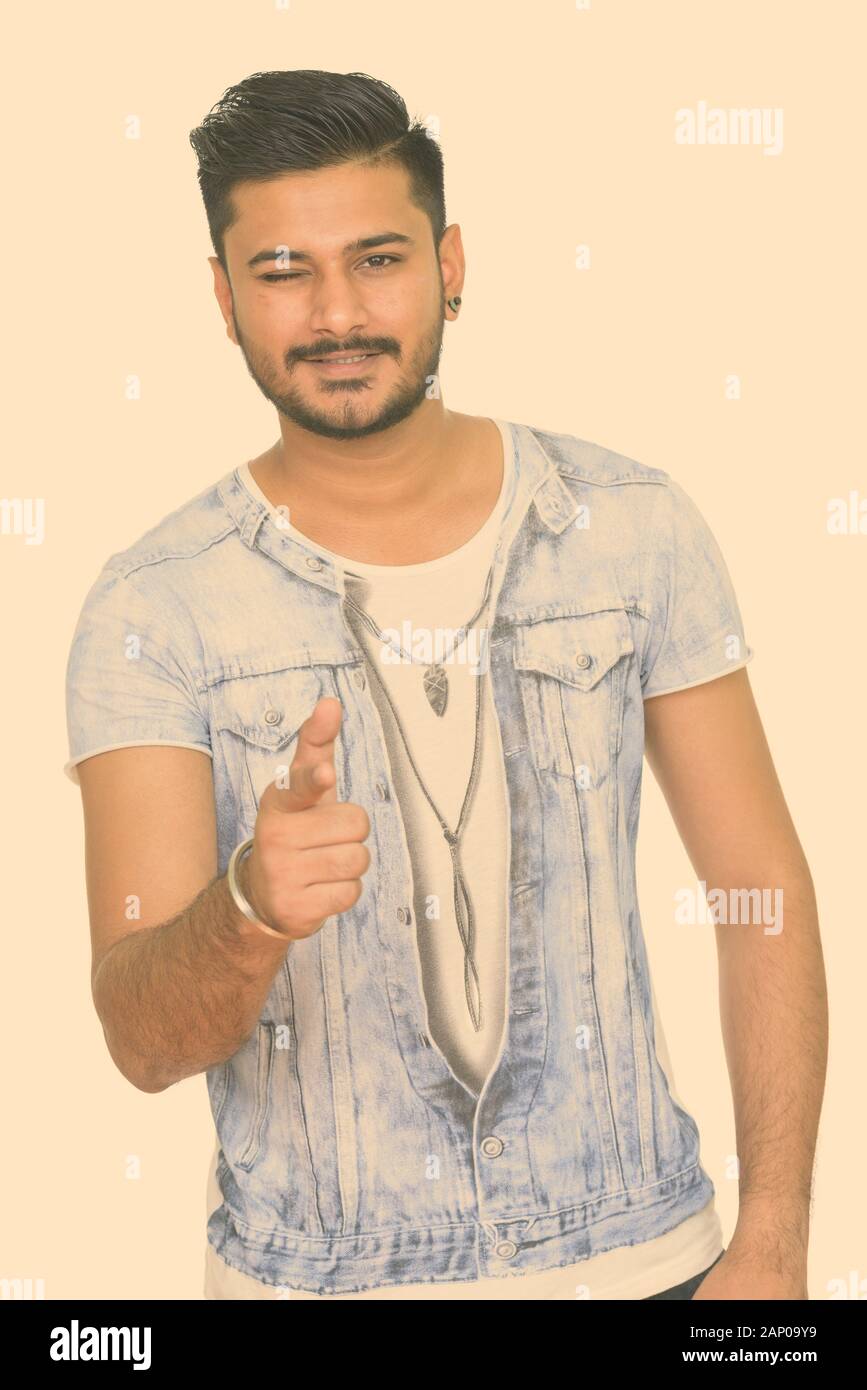 Young happy handsome Indian man winking and pointing finger Stock Photo -  Alamy, image size:867x1390