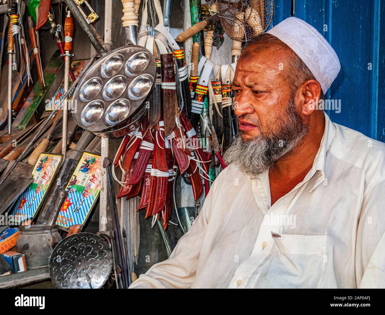 Uigur merchant selling hardware in the bazaar of the destroyed old part of the Oasis Stock Photo