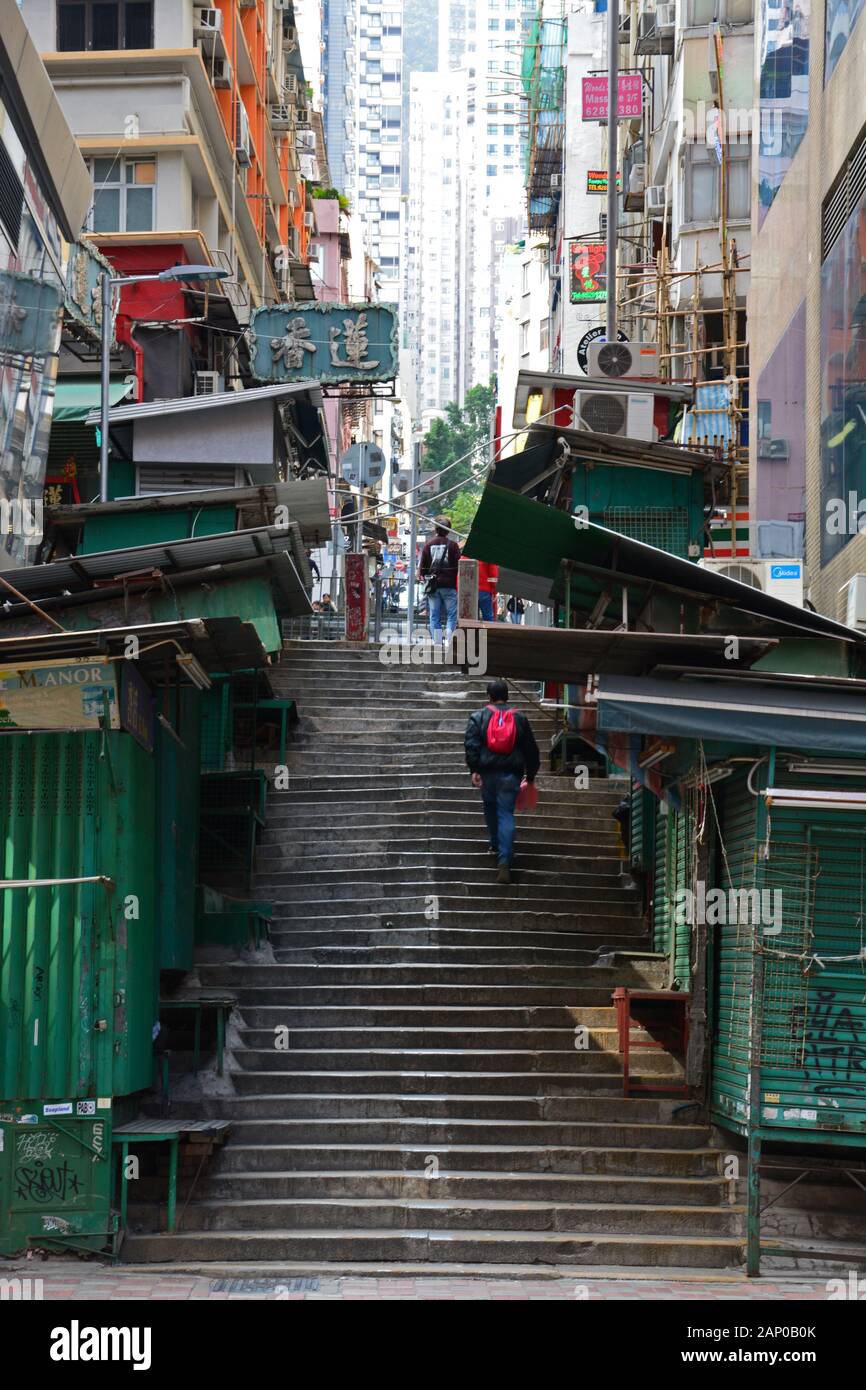A narrow set of stairs up the hill in the gritty Sheung Wan neighborhood of Hong Kong. Stock Photo