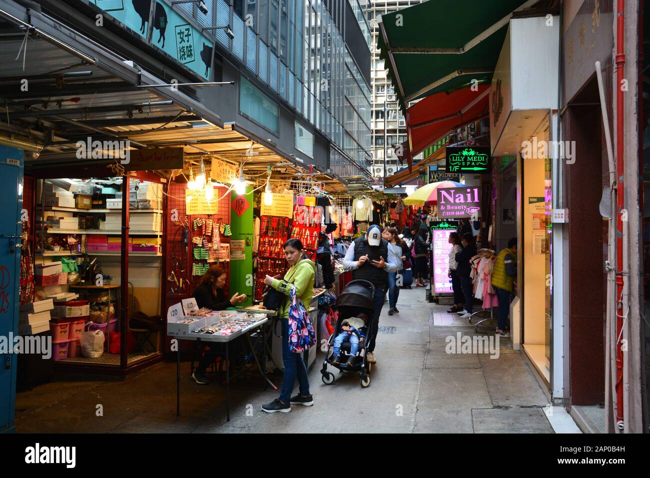 A narrow street market selling clothing in the Sheng Wan area of Hong Kong. Stock Photo