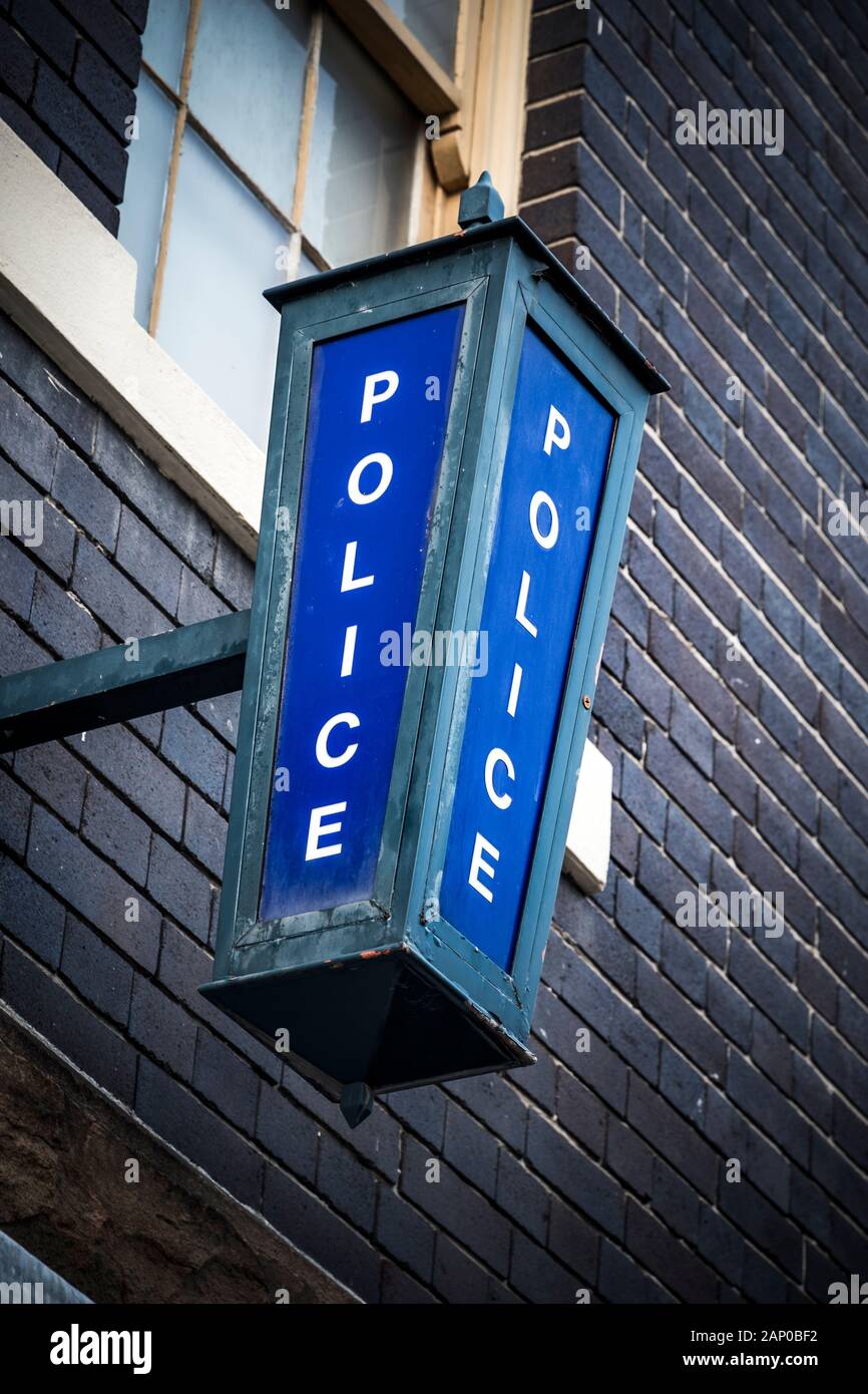 Police sign high on wall on exterior of police station Stock Photo - Alamy