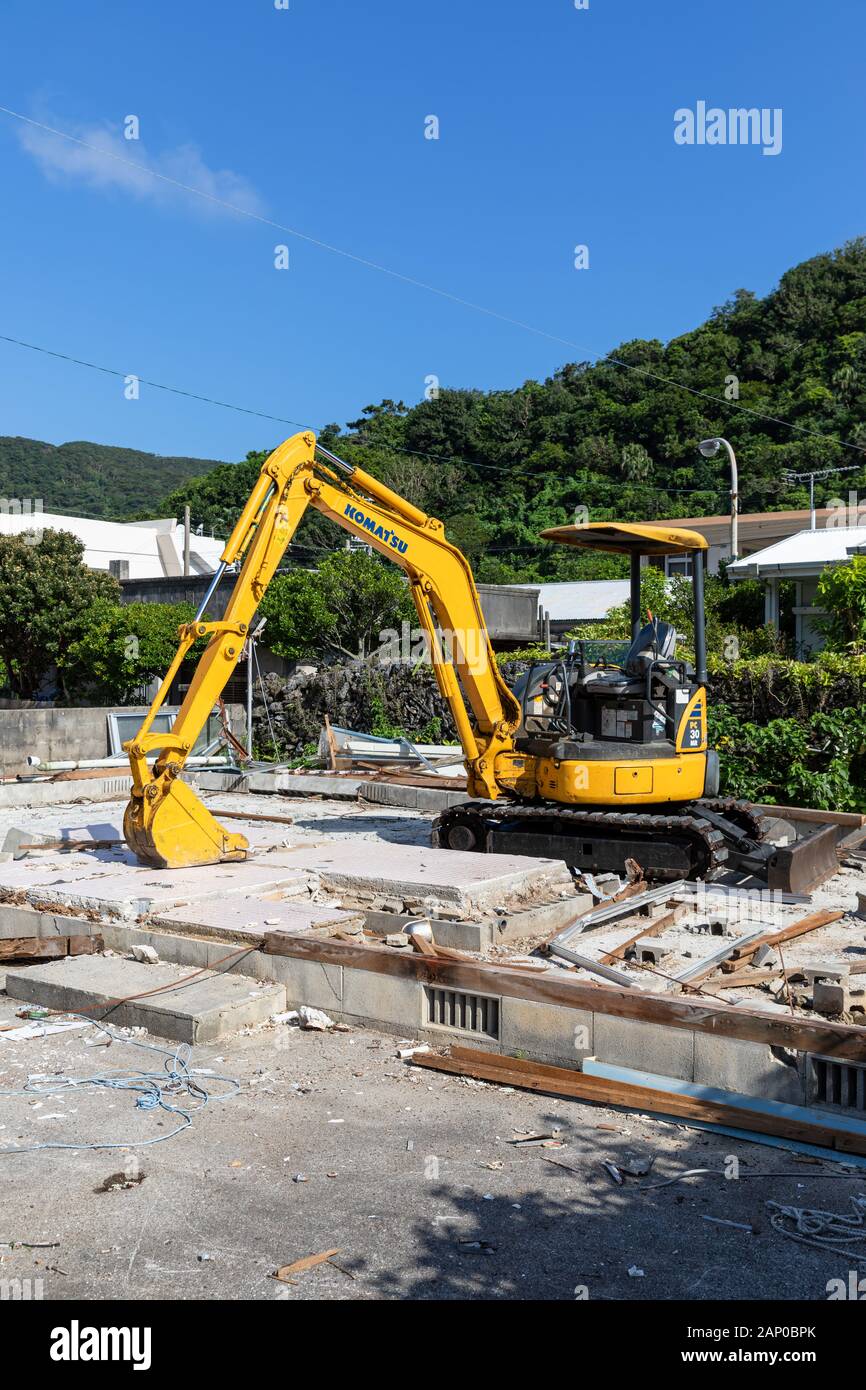 Komatsu PC30MR hydraulic mini excavator among the remains of a demolished house Stock Photo