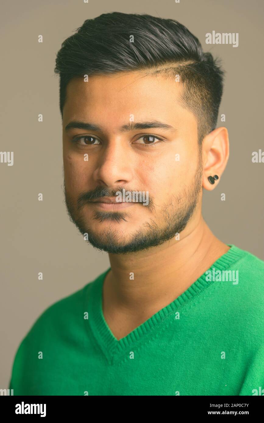 Face of young handsome bearded Indian man Stock Photo - Alamy