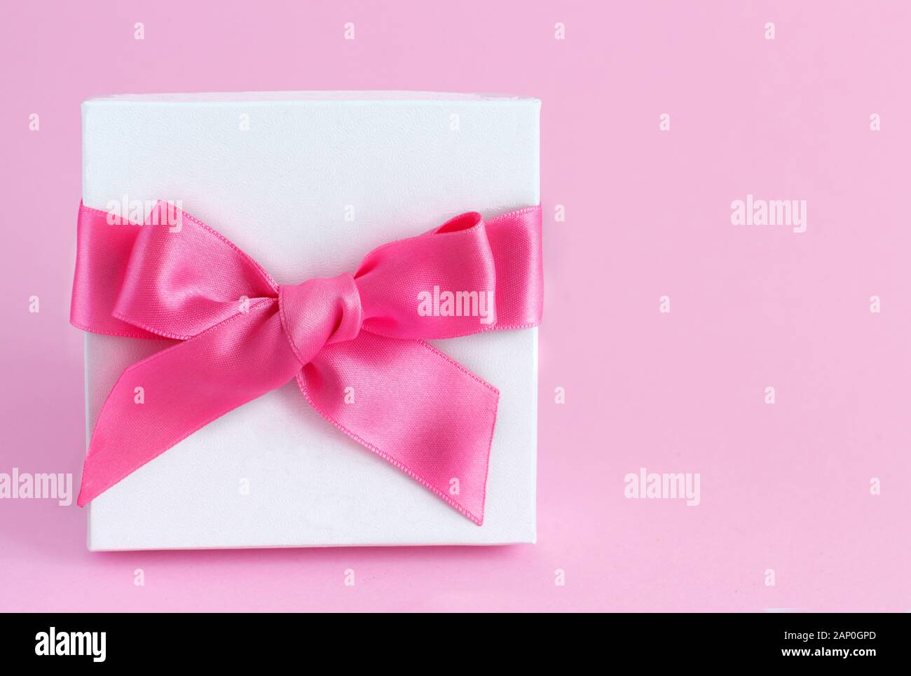 White gift box with a bow on a light pink background close up Stock ...