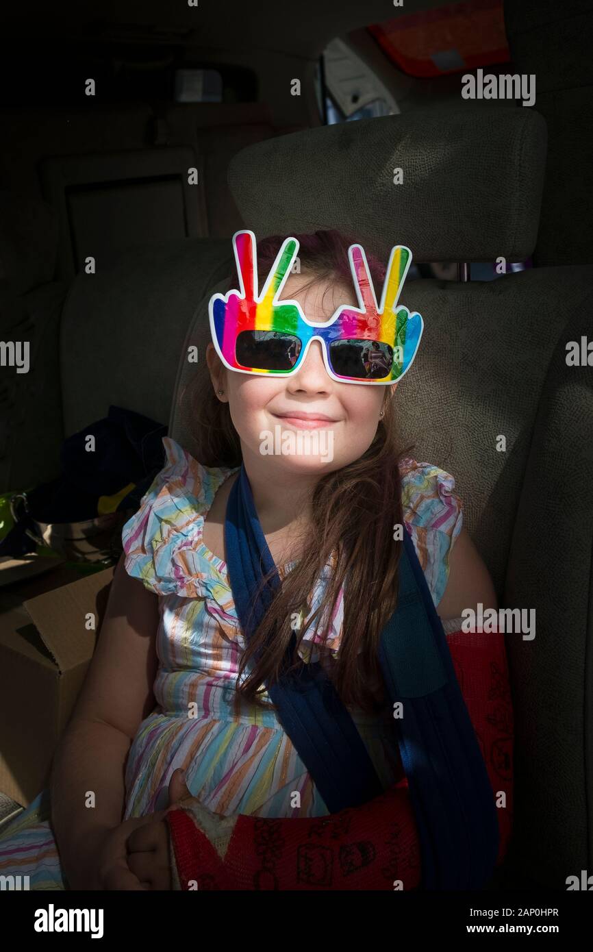 A young girl smiling and wearing novelty sunglasses Stock Photo Alamy
