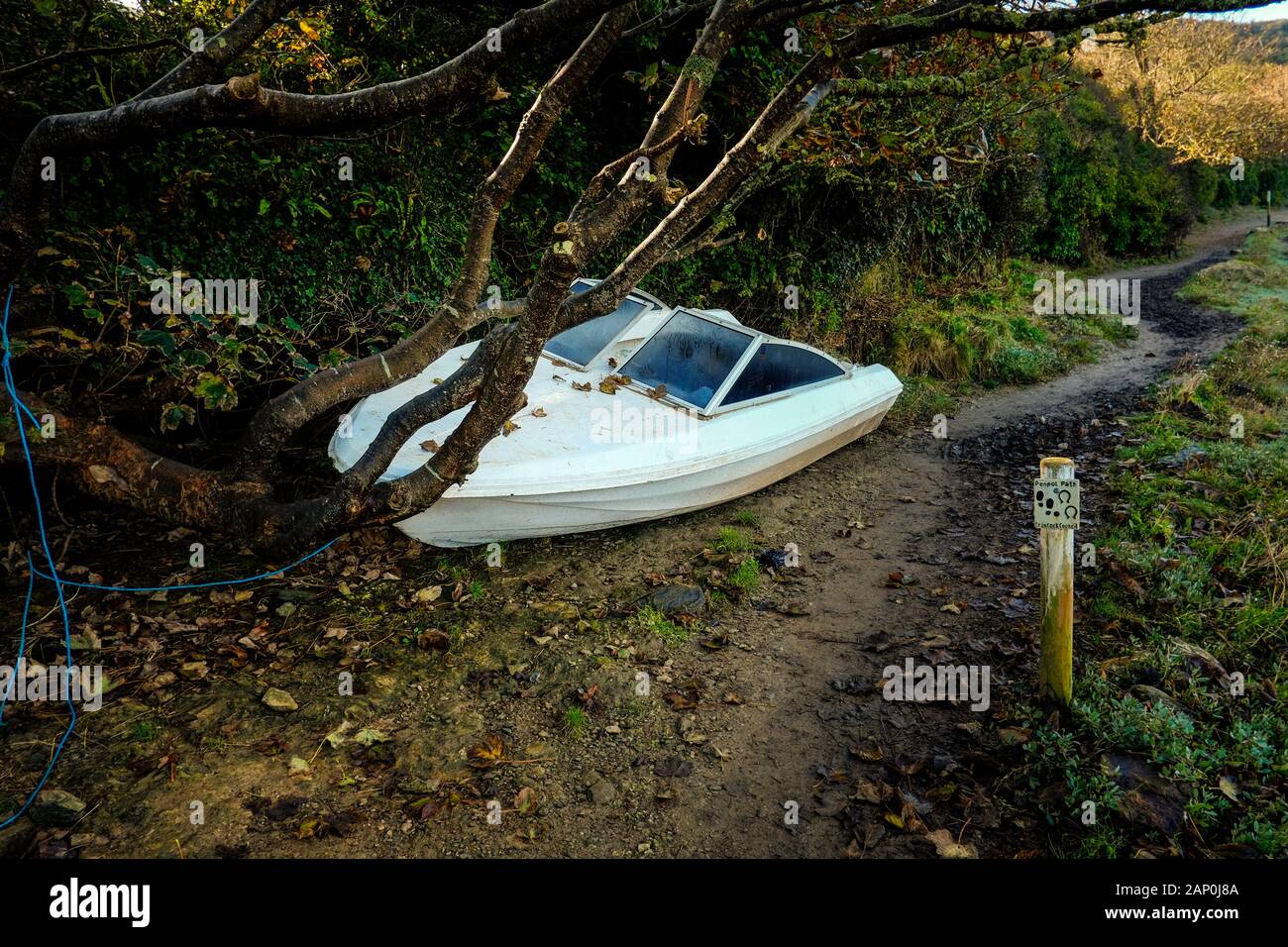 A small boat abandoned at low tide on the Gannel Estuary in Newquay in Cornwall. Stock Photo