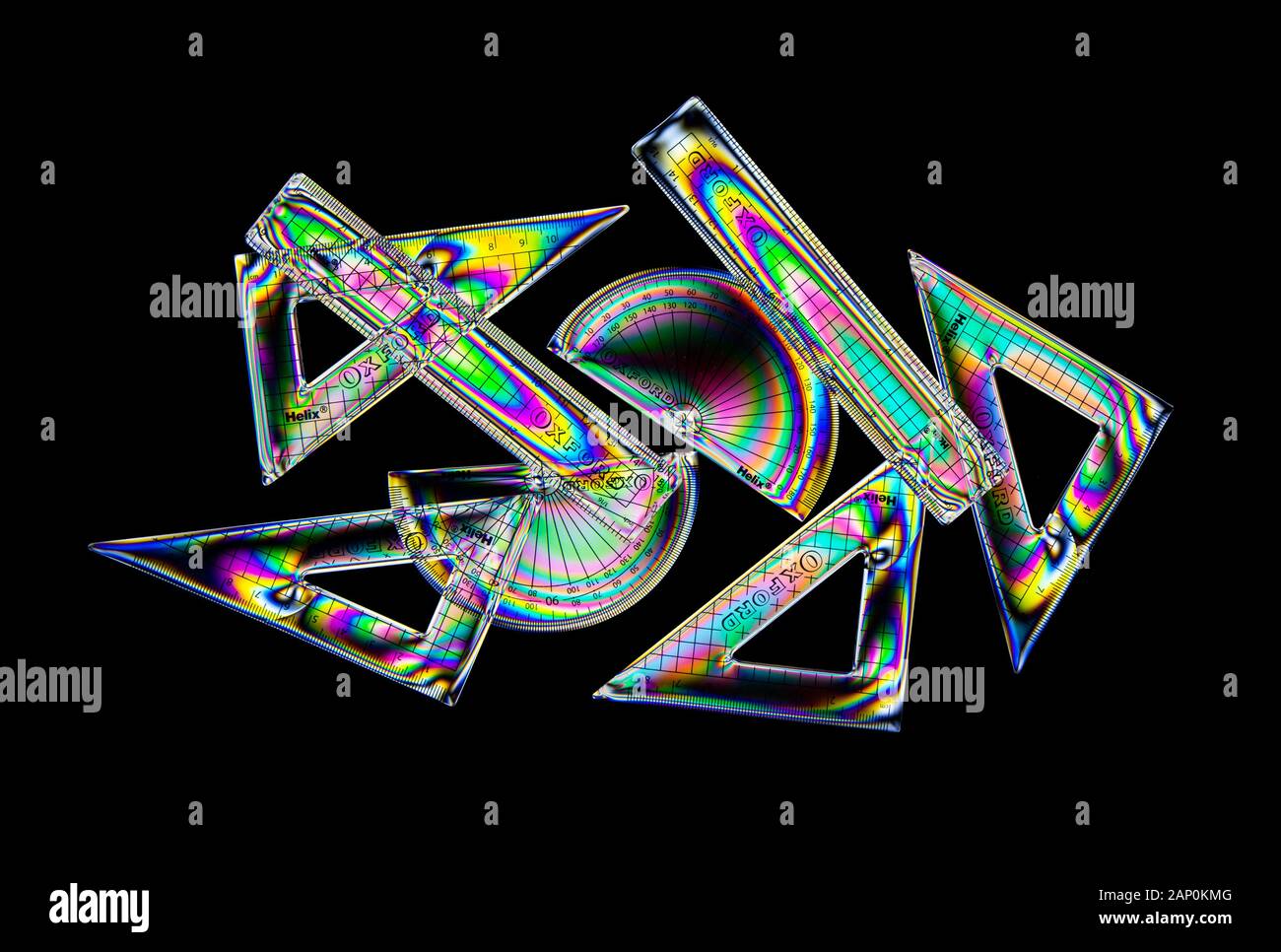 Colourful stress patterns in hard plastic, revealed by imaging between two crossed polarising filters, showing a range of school geometry aids Stock Photo
