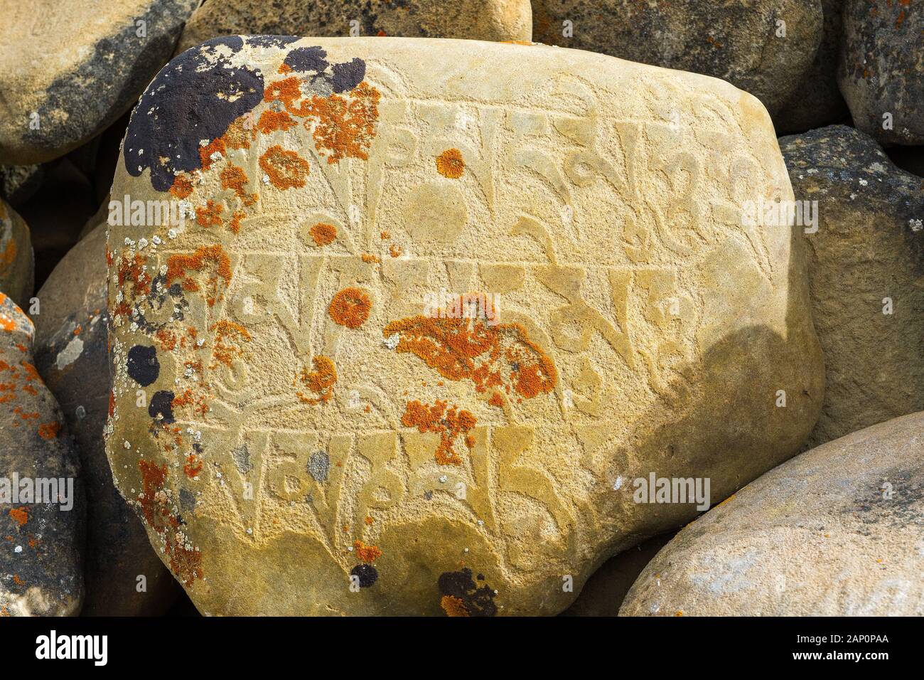 A carved stone with Buddhist mantra on a mani wall in the Nepal Himalayas Stock Photo
