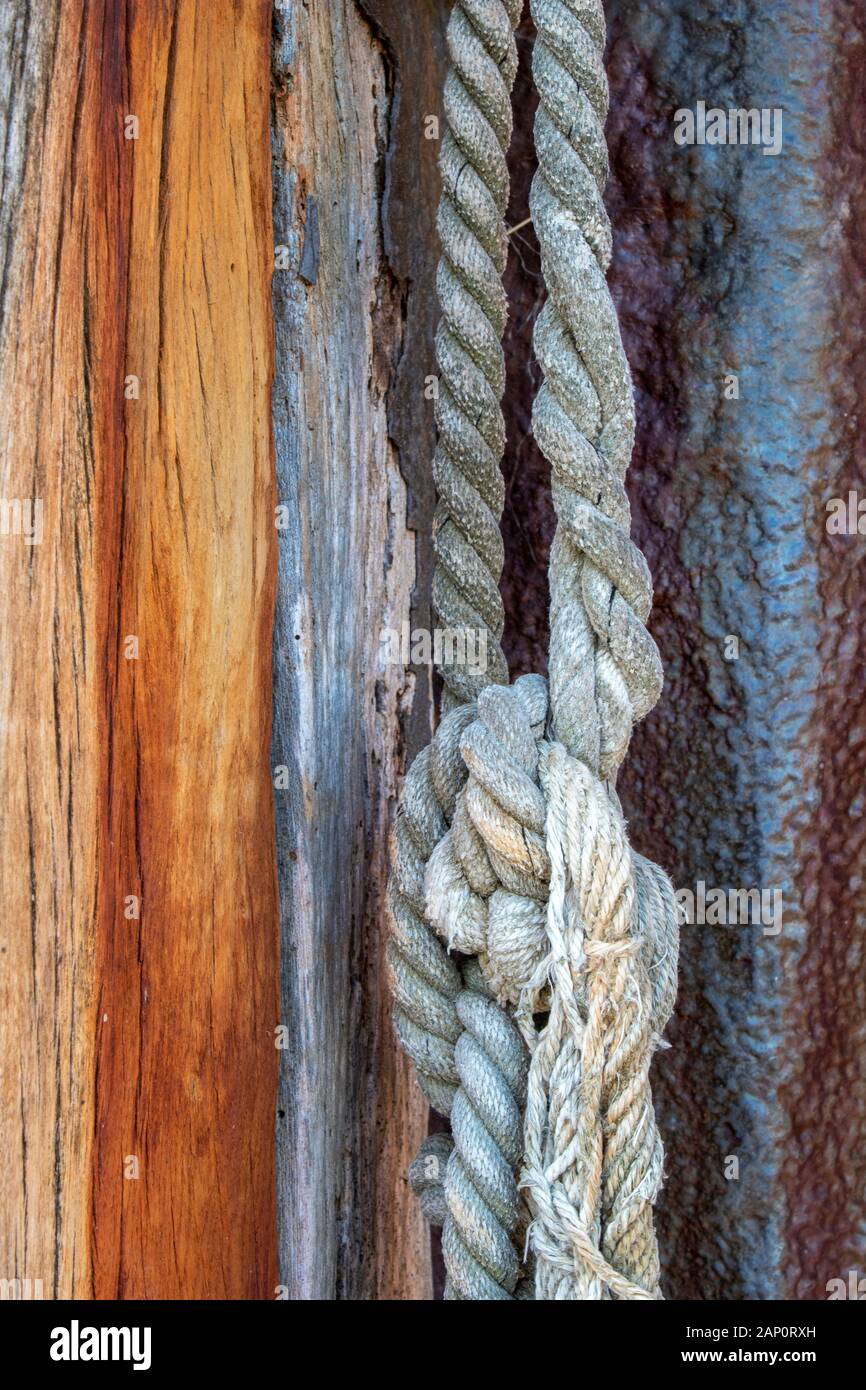 Old nautical rope hanging from a weathered wooden post at Old Leigh