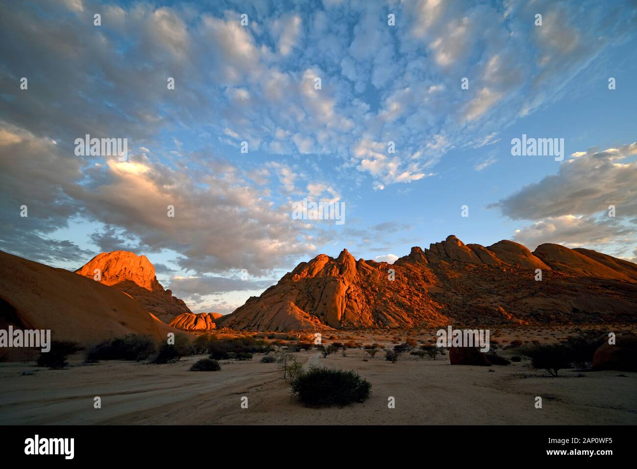 Morning light mood shortly after sunrise in the Spitzkoppeggebiet, taken on 03.03.2019. The Spitzkoppe region and the surrounding side peaks with their rock formations belong to one of the landmarks of Namibia, it rises to a height of 1728 meters above sea level. A paradise for climbers and hikers, the area is 120 kilometers northwest of Swakopmund and is sometimes difficult to reach. The formation, which was visible from afar, was created 100 million years ago by volcanic activity, which eroded softer cover rock, so that today only the harder granite rock can be seen in its bizarre forms. Pho Stock Photo