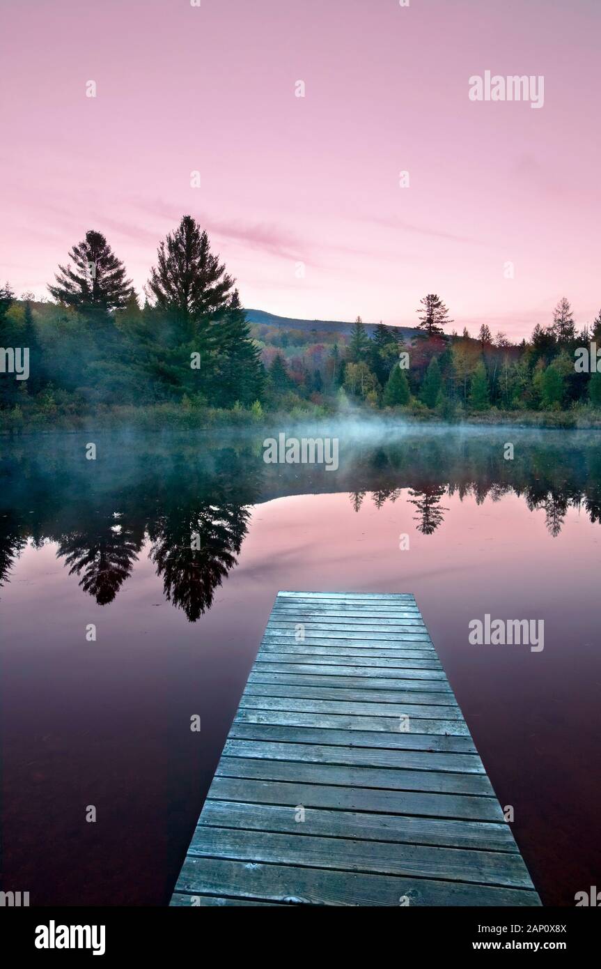 Sunrise over pond with Jetty, White Mountains National Forest, New Hampshire, USA Stock Photo