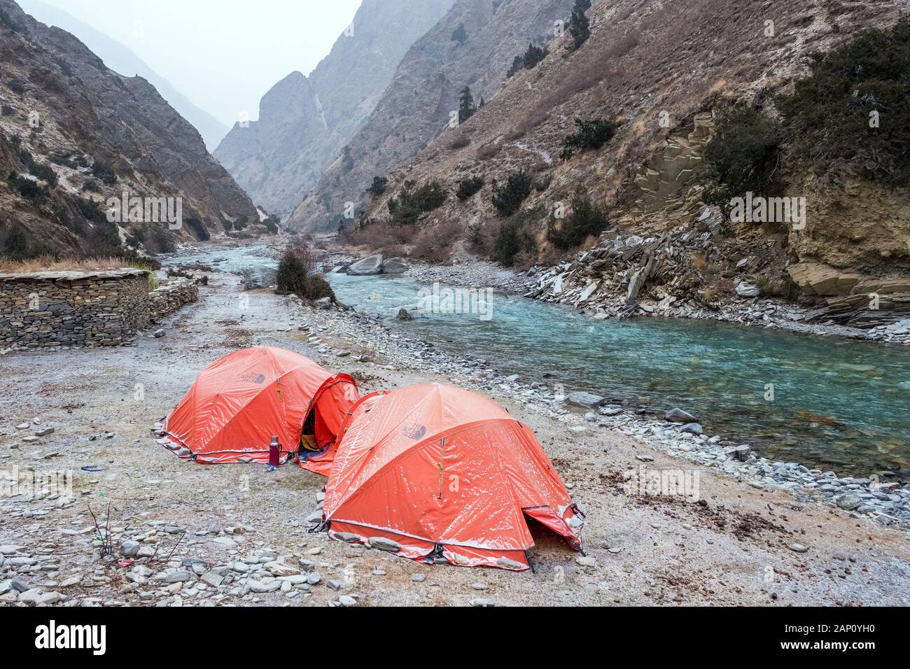 Two tents pitched beside a river in a gorge on the Lower Dolpo Trek in Nepal Stock Photo