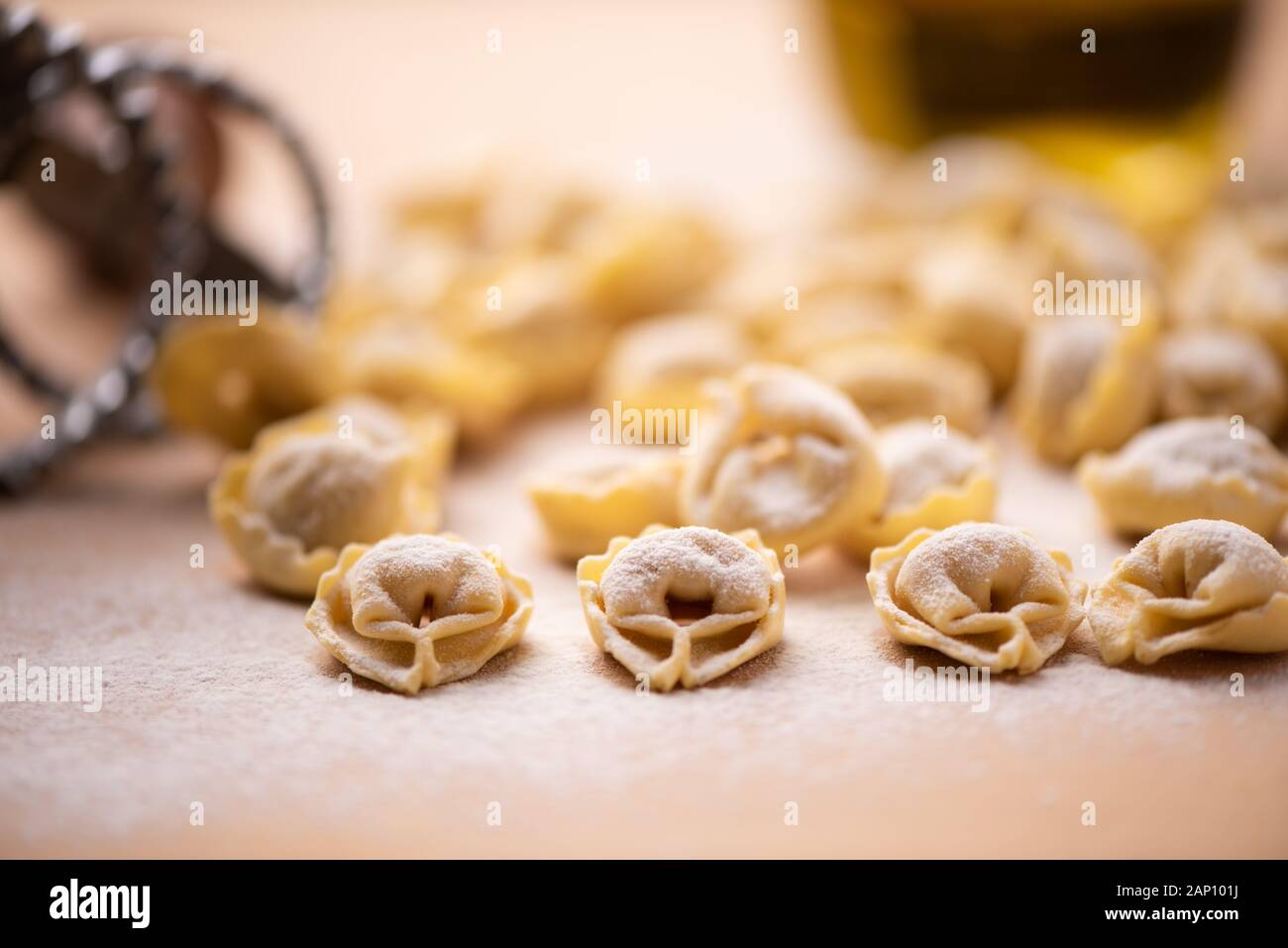 Tortellini or Tortelloni pasta on a flour dusted board close up Stock