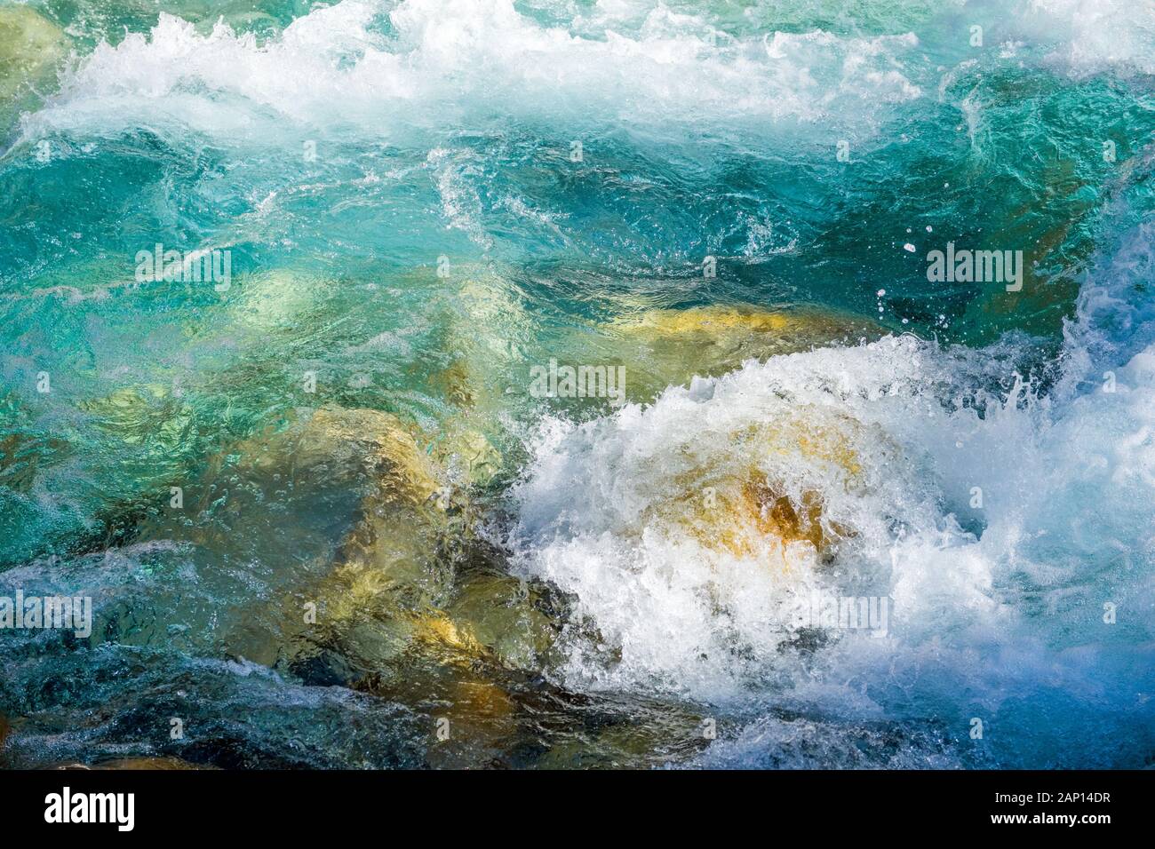 Clear mountain river water tumbling over boulders in the Nepal Himalayas Stock Photo
