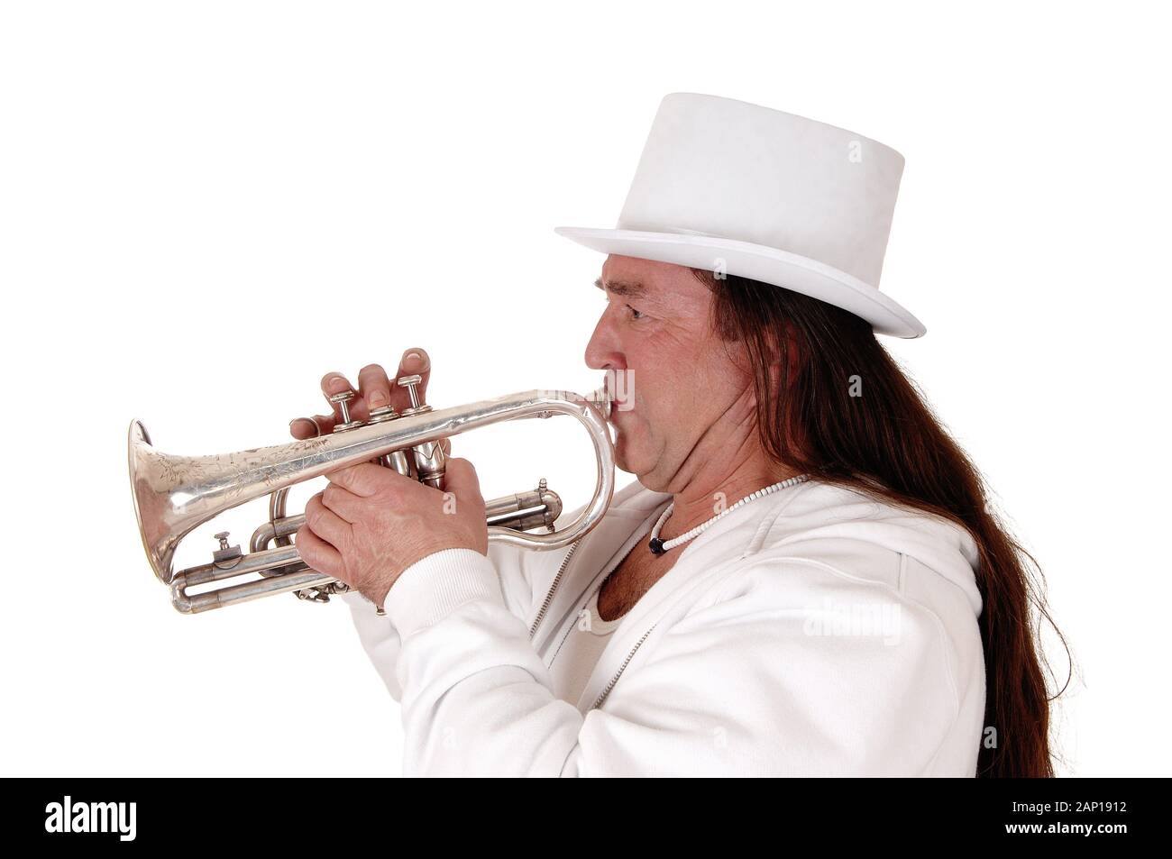 A middle age indigenous man standing in a white outfit and white hat playing his trumpet with his long hair, isolated for white background Stock Photo