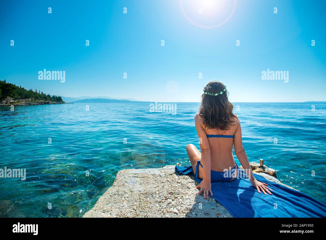 European woman sunbathing with sea view, Nissaki Beach, Corfu, Ionian islands, Greece Stock Photo