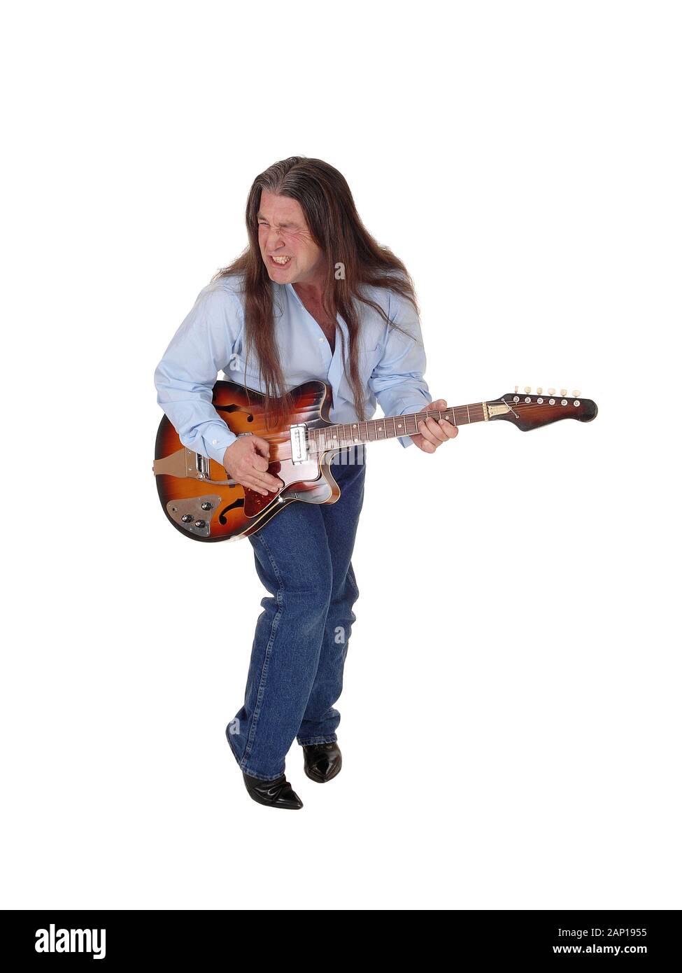 A happy musician playing his guitar with his long brunette hair, singing, isolated for white background Stock Photo