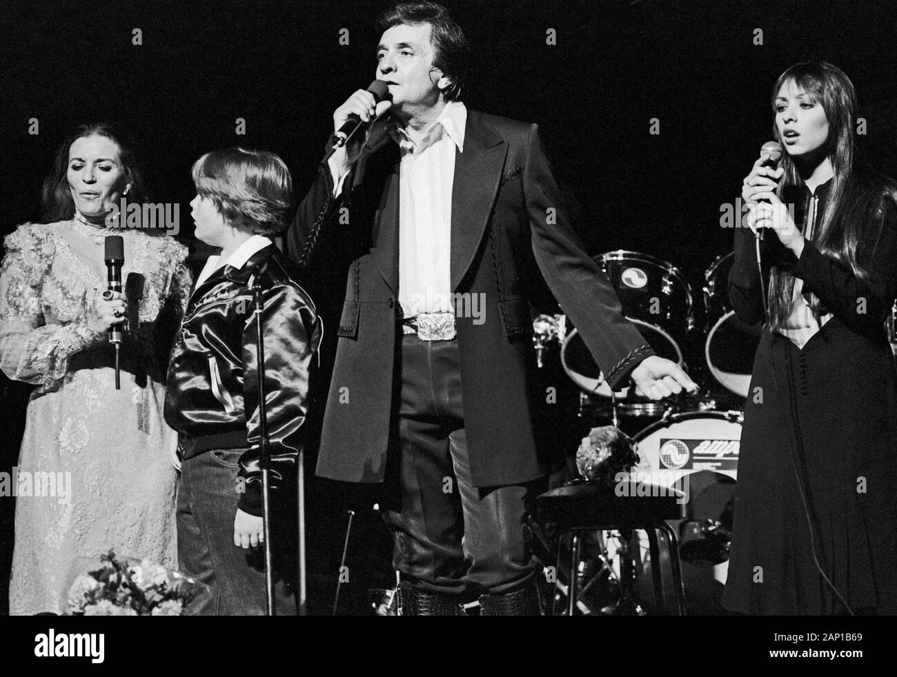 Johnny Cash, amerikanischer Country Sänger und Songschreiber, bei einem Konzert in Hamburg mit Ehefrau June Carter Cash und einem kleinen Jungen, Deutschland um 1981. American country singer and song writer Johnny Cash, his wife June Carter Cash and a little boy performing at Hamburg, Germany, around 1981. Stock Photo