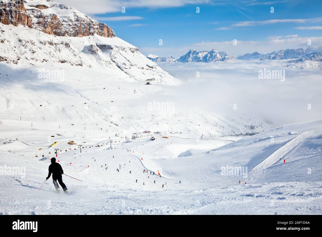 Skier going down the slope at Sella Ronda ski route in Italy Stock Photo