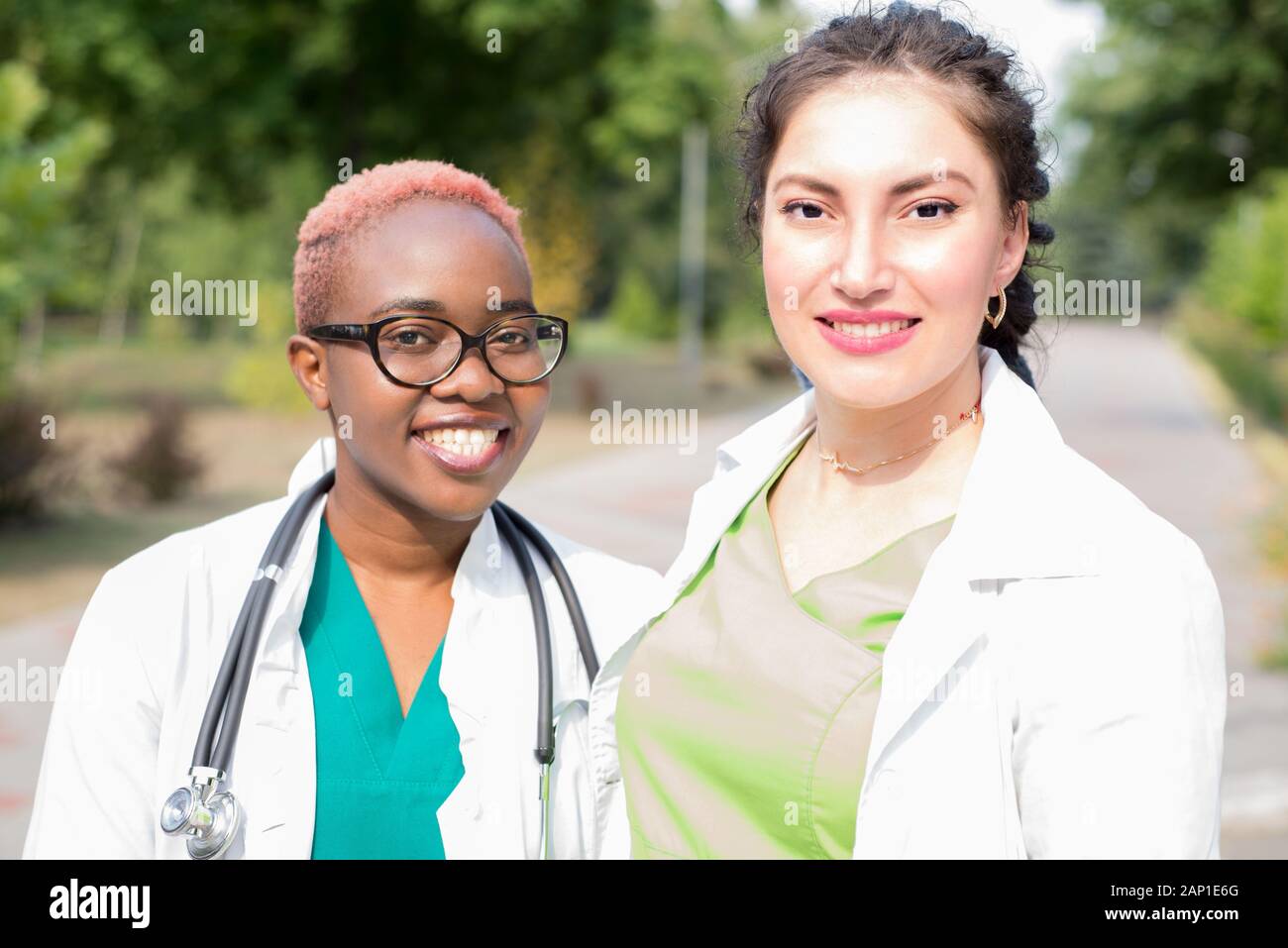Portrait of smiling doctors, mixed race. Black girl, white girl