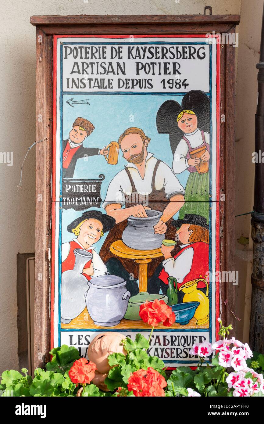 A tile advert and image of potters making pots for the Poterie de Kayserberg - an artisan potters shop in Alsace France Stock Photo