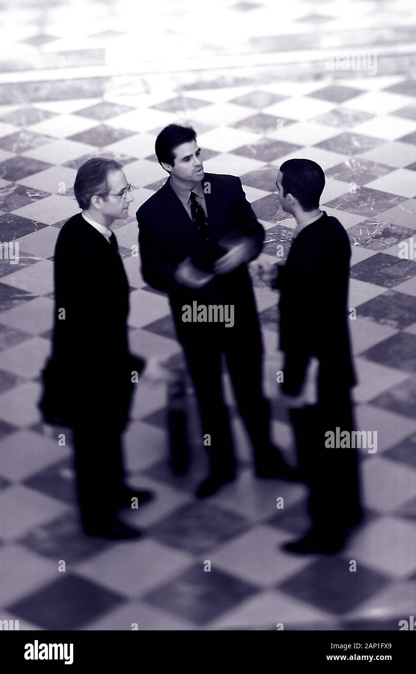 Three executives discussing and meeting in the lobby Stock Photo