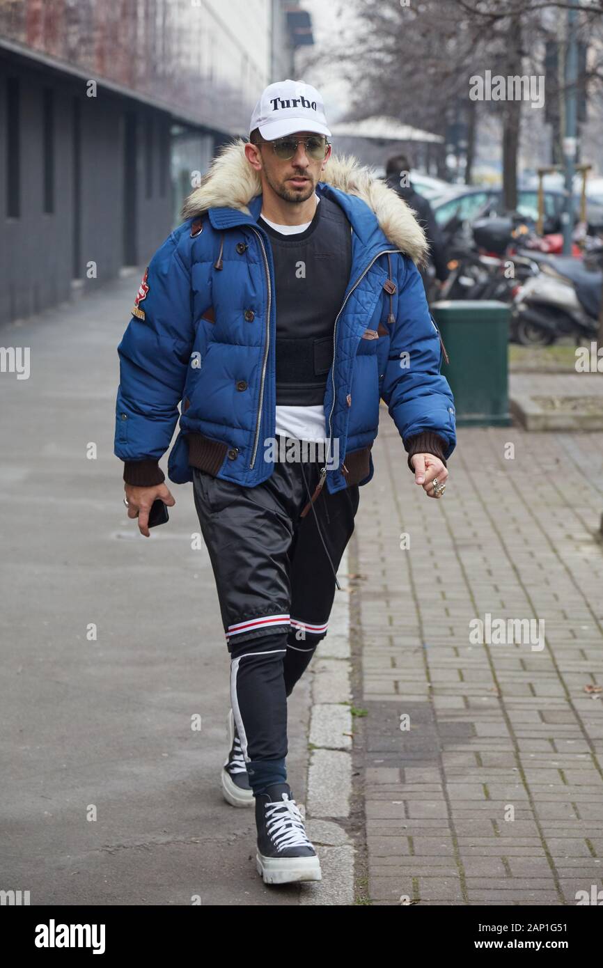 MILAN, ITALY - JANUARY 14, 2019: Man with blue bomber jacket with fur hood before Marco de Vincenzo fashion show, Milan Fashion Week street style Stock Photo