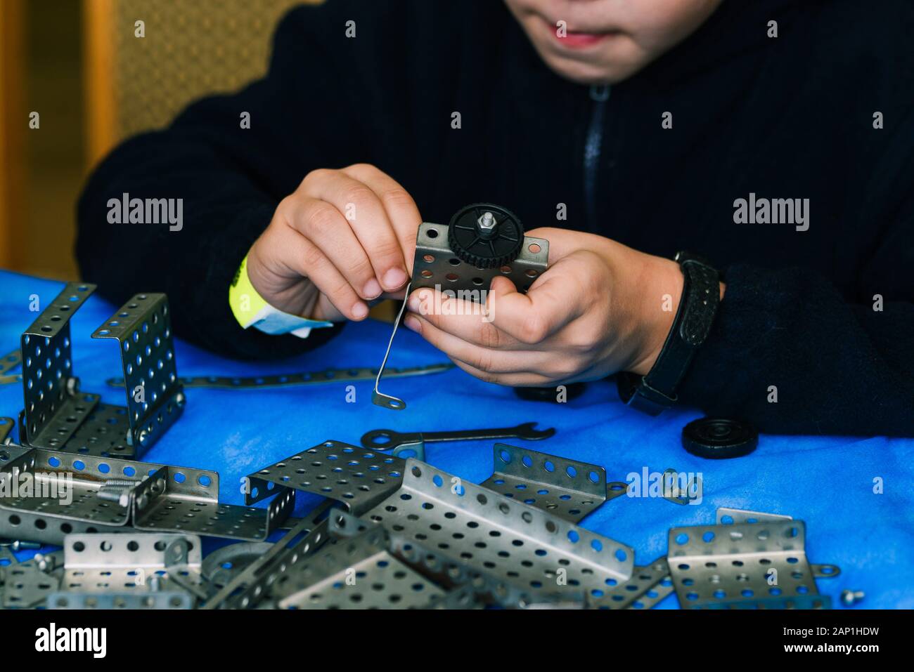 The child collects the constructor. Engineering constructions in miniature. Children's set designer for boys. The development of motor skills of hands Stock Photo