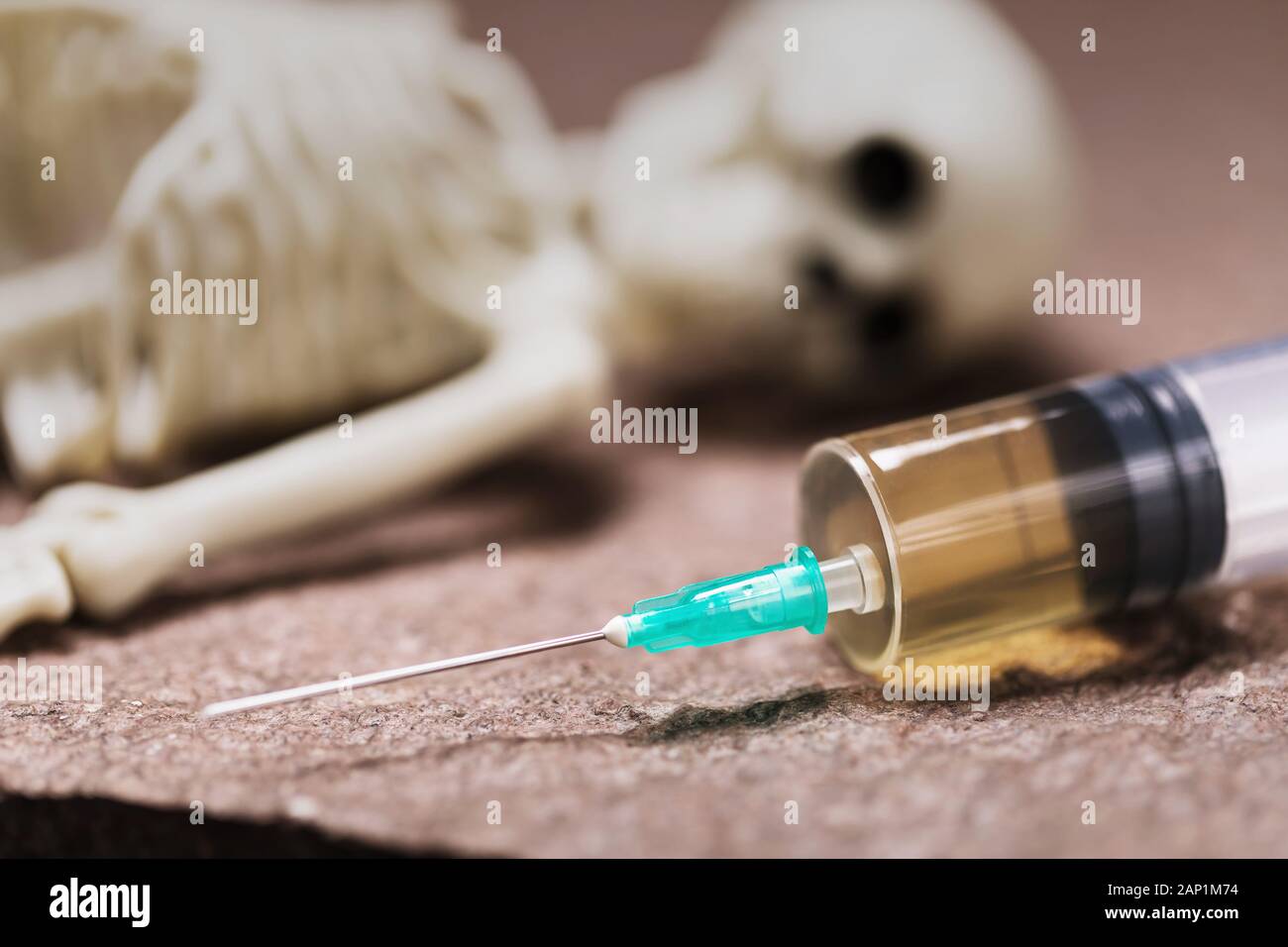 Syringe and human skeleton, closeup. The concept of mortal danger from drugs Stock Photo