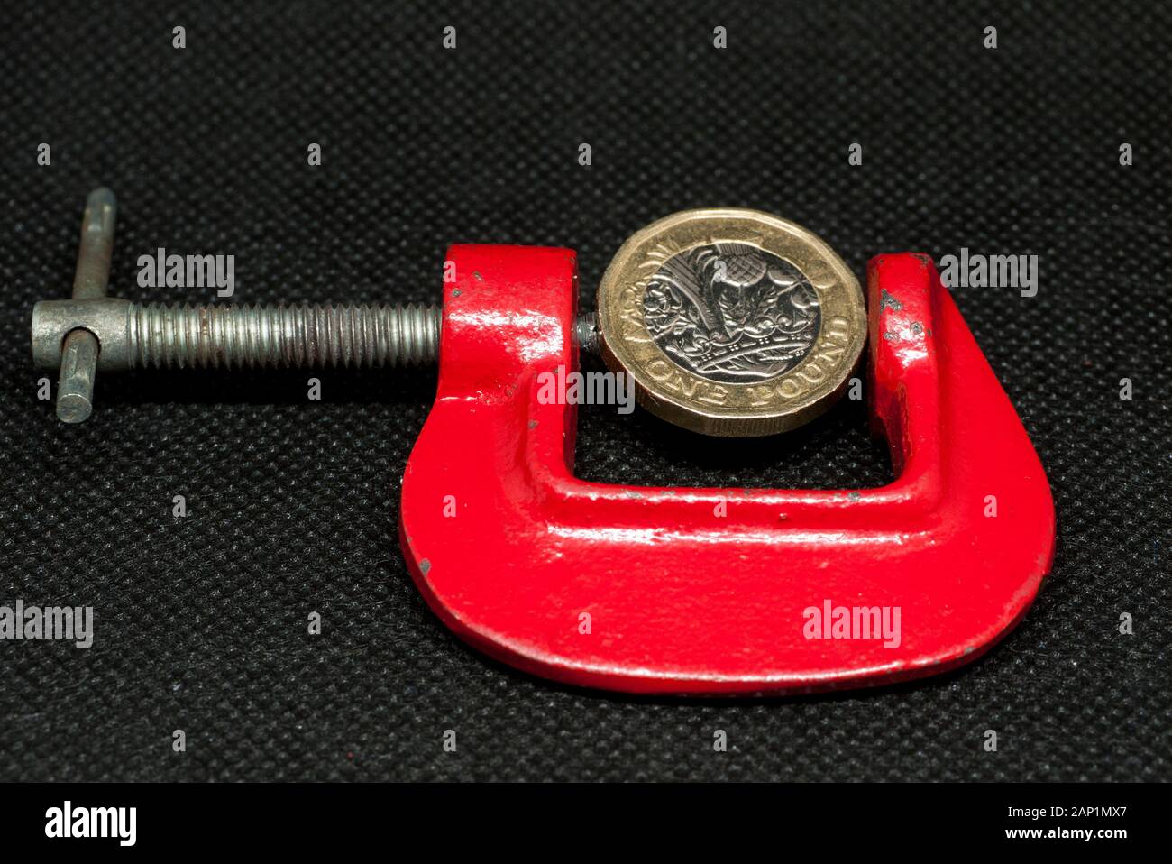 One Pound British Coin in a C Clamp, Uk. Stock Photo