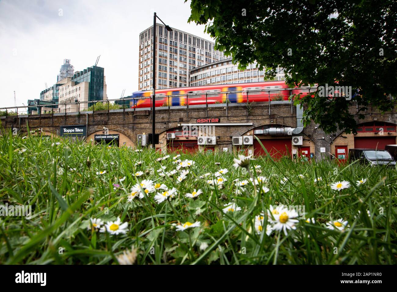 High rise buildings of the London district of Vauxhall overlook the railway's speeding trains and Vauxhall Pleasure Gardens park. Stock Photo