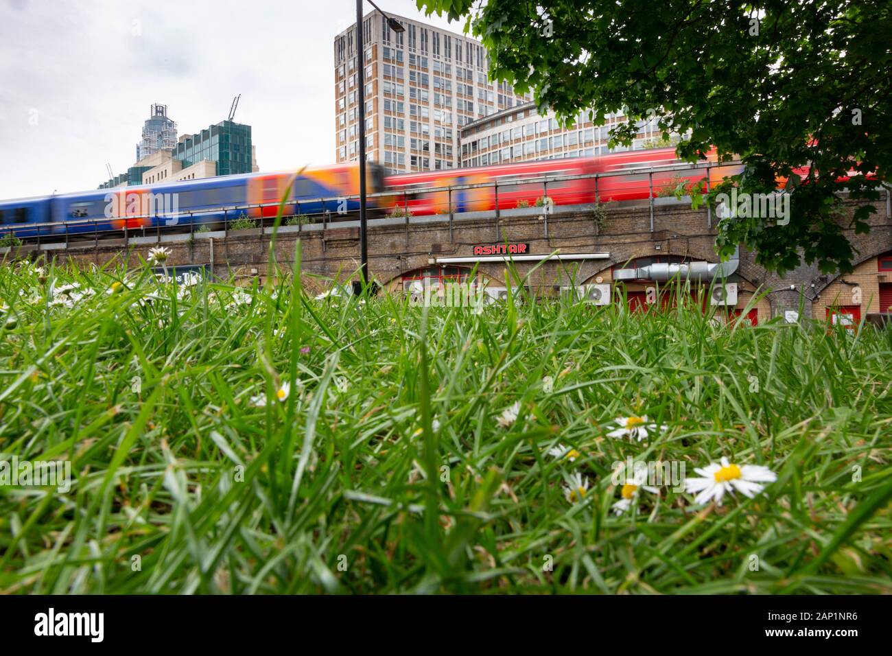High rise buildings of the london district of Vauxhall overlook two speeding railway trains and Vauxhall Pleasure Gardens park. Stock Photo