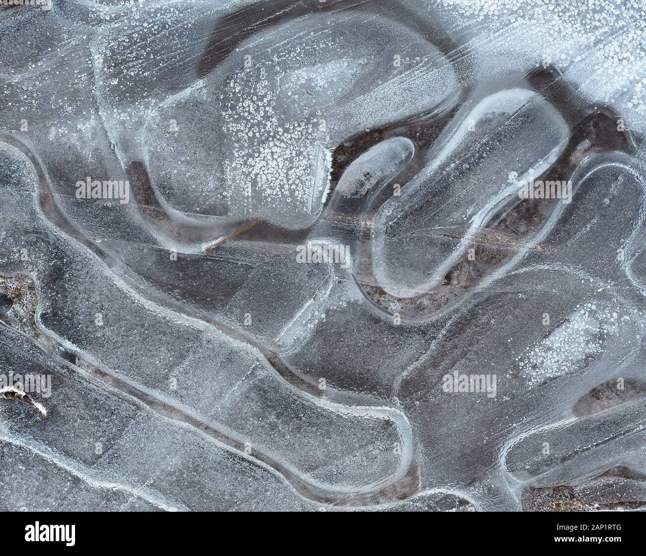 Abstract image of crack pattern in frozen puddle. Stock Photo