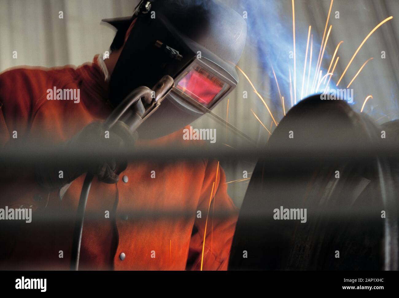 Sparks flying as a Skilled workmen is welding steel pipe Stock Photo