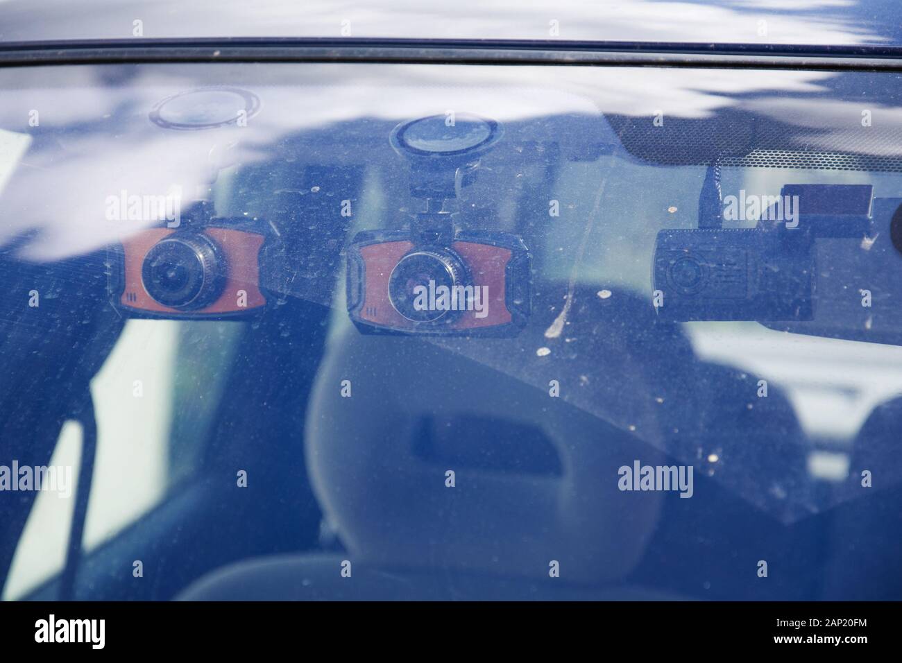 Three dashboard camera mounted on the dirty front windshield. Car Camera DVR Dash Cam for safety on the road accident. View from outside the car. Stock Photo