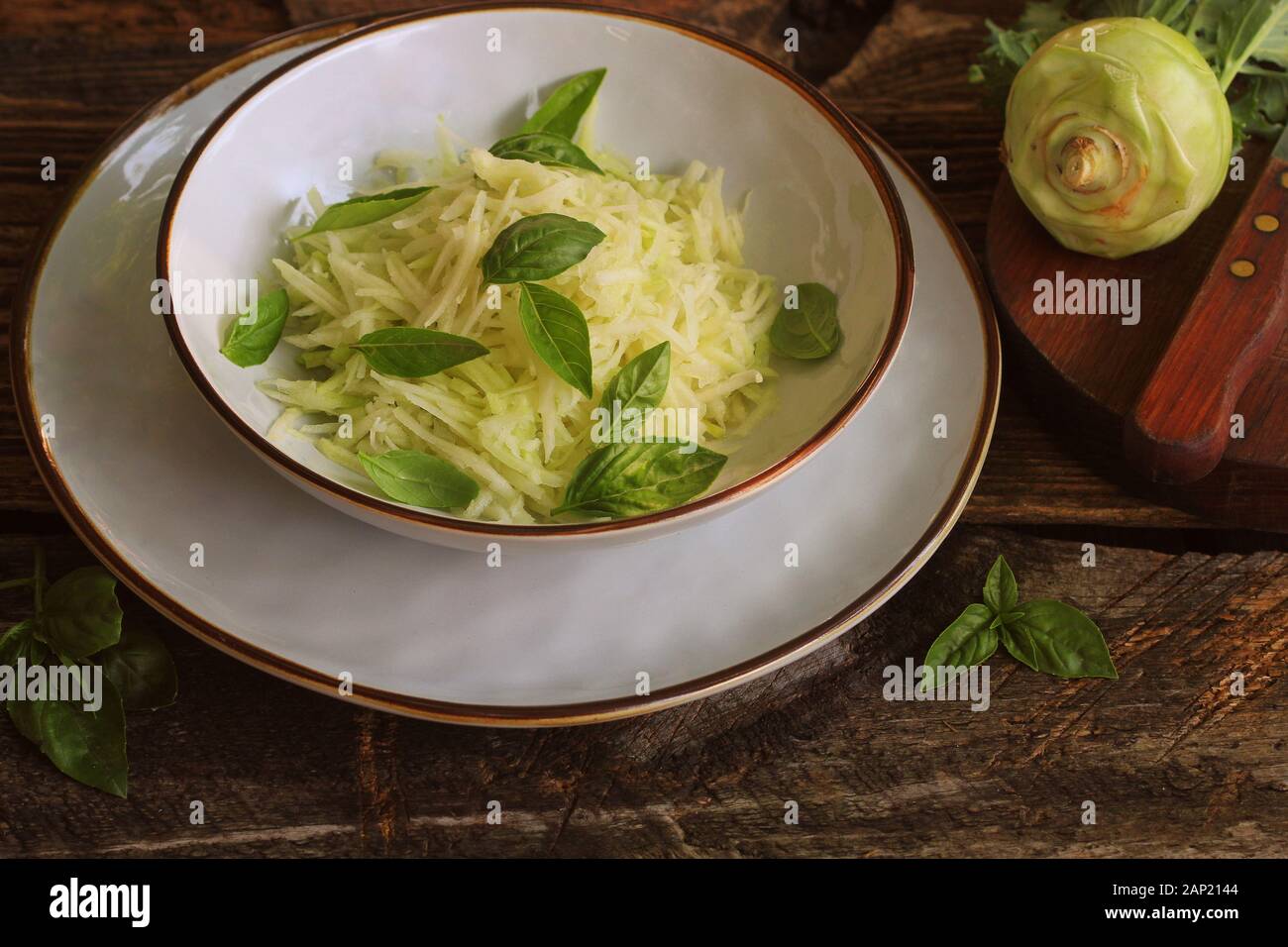 Fresh salad with kohlrabi, parmesan, basil and sesame dresing in a bowl. Vegetarian food Stock Photo