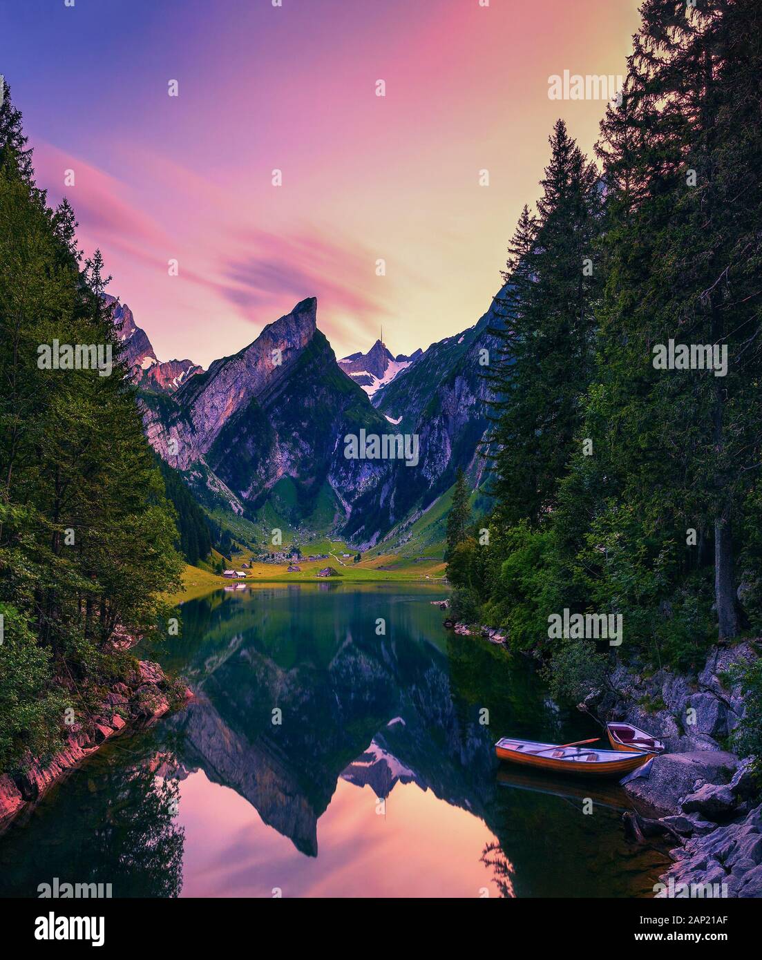 Sunset over the Seealpsee lake with small boats in the Swiss Alps, Switzerland Stock Photo