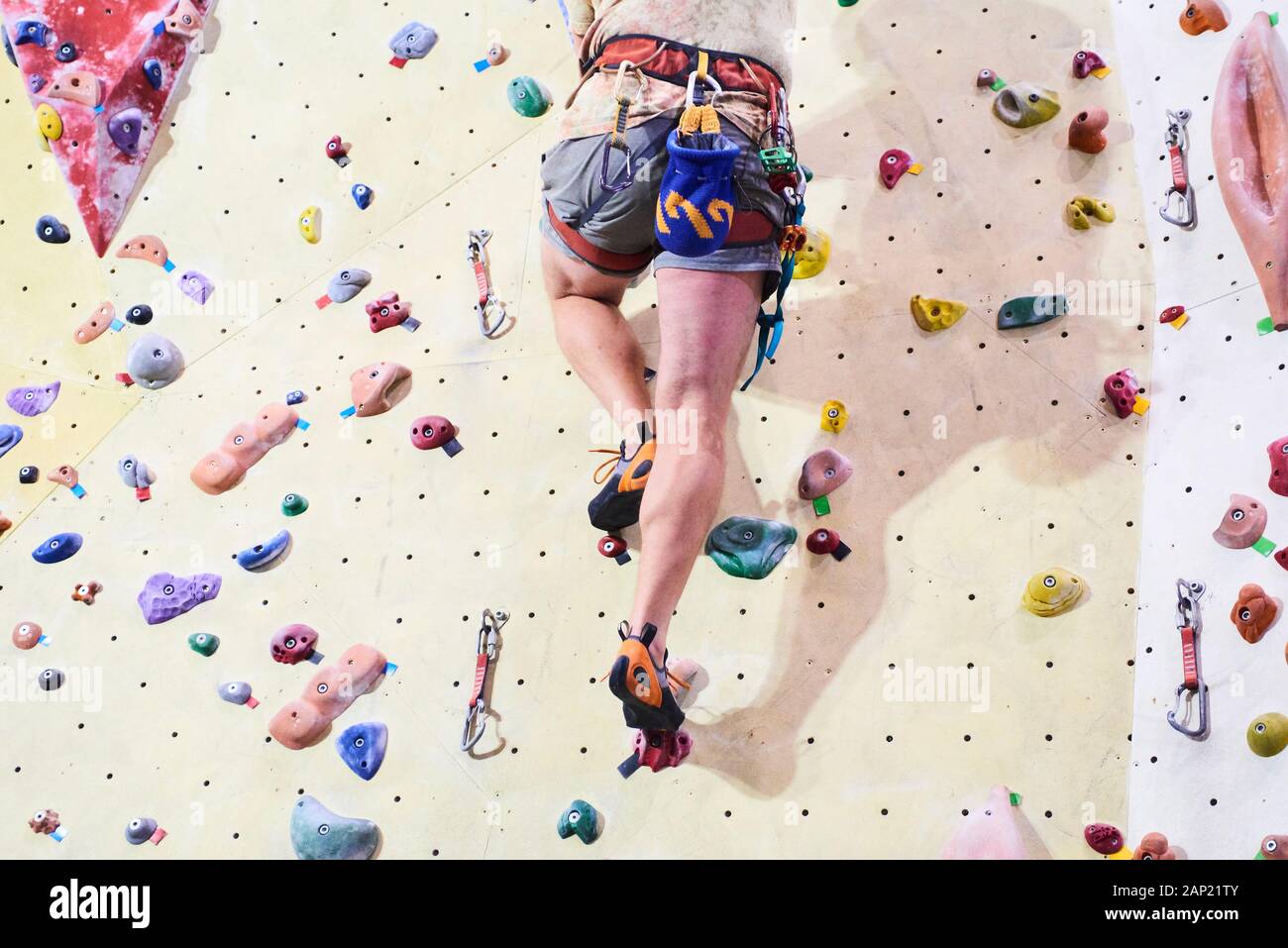 Man climbing wall in bouldering gym. Detail on legs and equipment Stock Photo Alamy