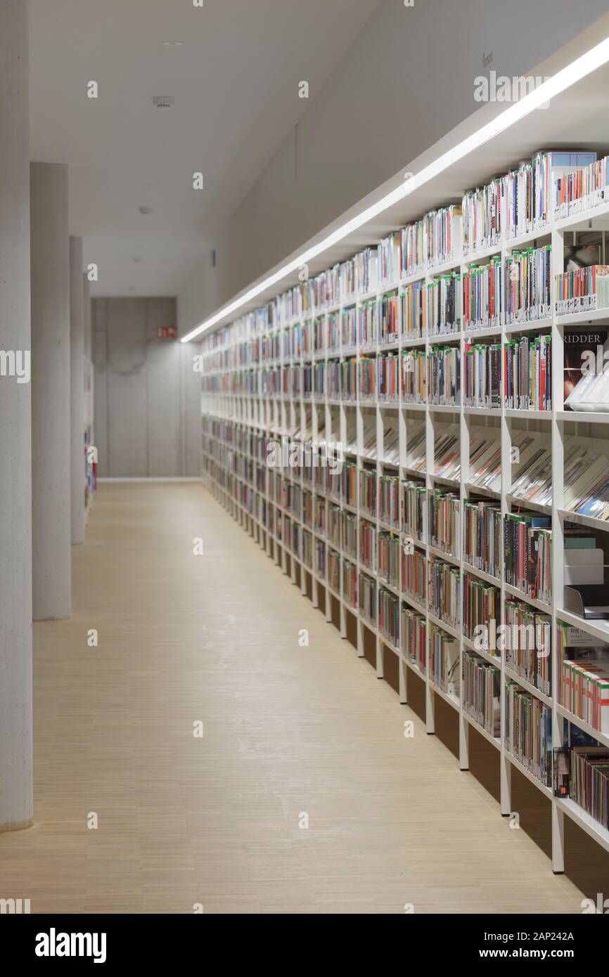 Bookshelves in library with concrete columns. Cultuurcentrum De Factorij, Zaventem, Belgium. Architect: ebtca Architecten & Archiles architecten , 201 Stock Photo