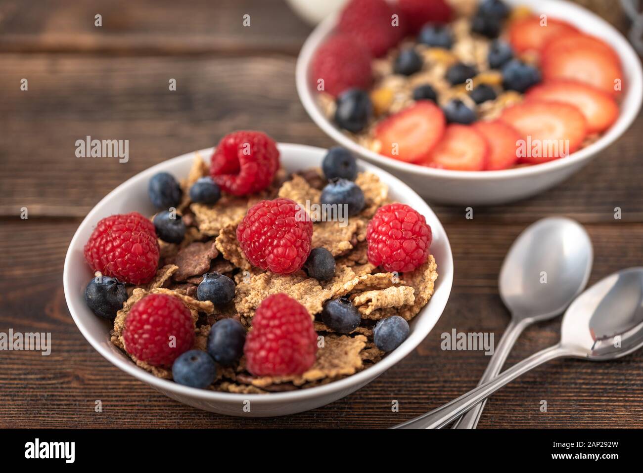 Granola chips with blueberries and raspberries in white bowl Stock