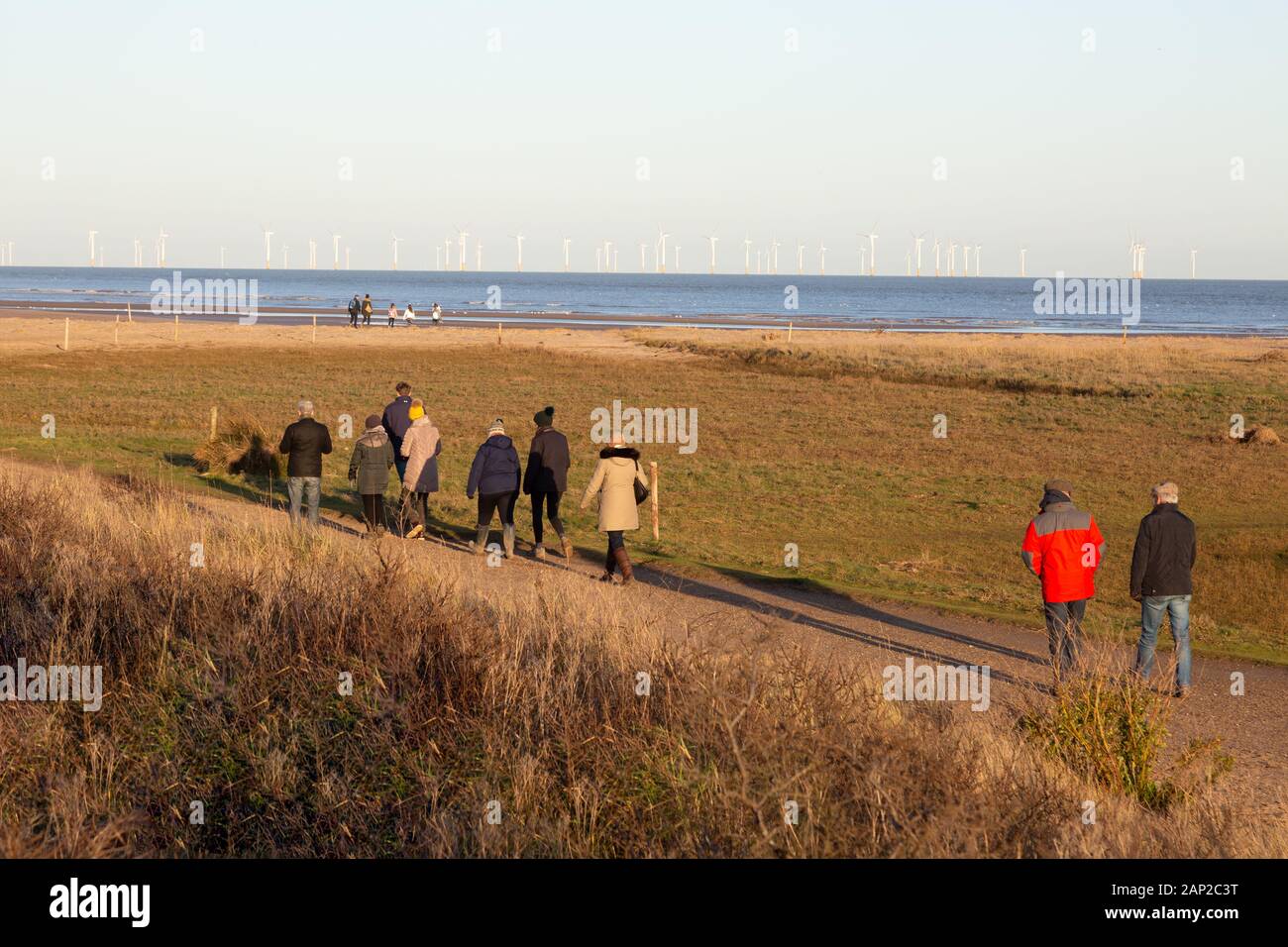 Gibraltar Point National Nature Reserve Lincolnshire UK- People walking on the Lincolnshire Coast by the North Sea and offshore windfarm, Lincolnshire Stock Photo